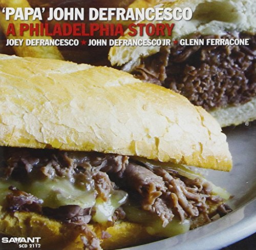 "CD cover featuring a close-up of a cheesesteak sandwich on a white plate."