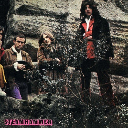 "Album cover featuring four men standing in front of a rocky wall."
