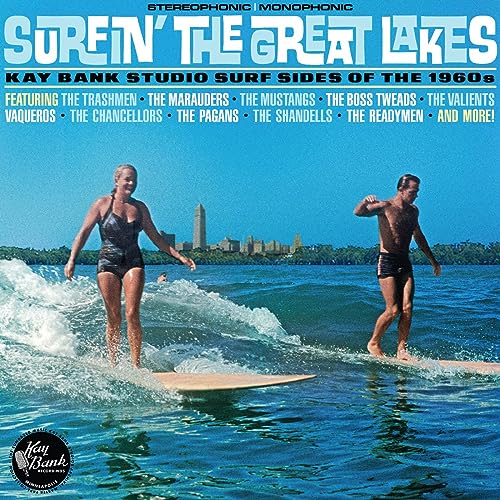 CD cover: two surfers on waves with a city skyline background.