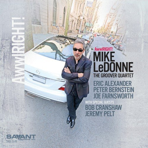 Album cover with man standing by a white car, wearing sunglasses and a suit.