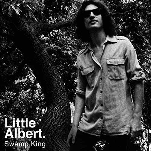 Black and white album cover with a man standing beside a tree, wearing sunglasses.
