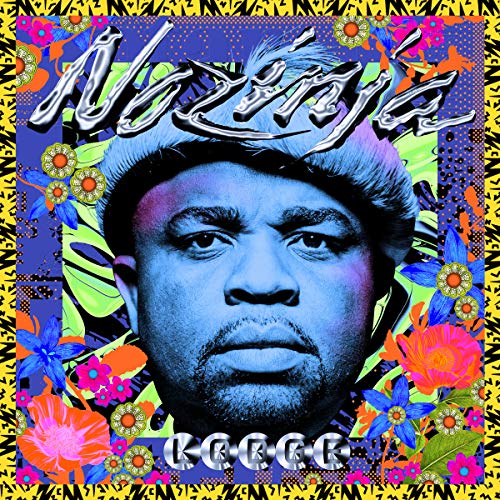 Close-up portrait of a man in a hat surrounded by colorful floral patterns.