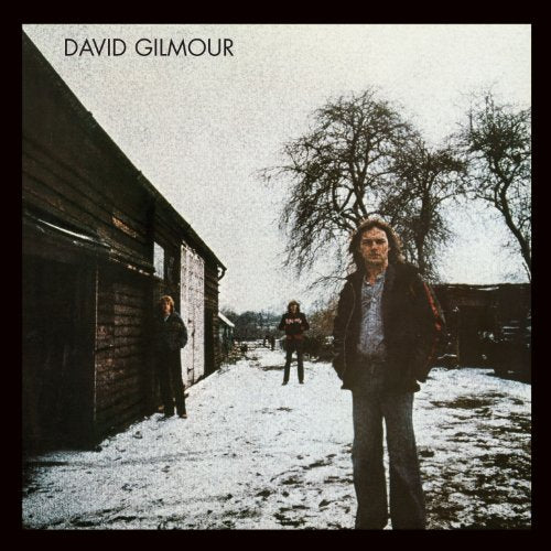 David Gilmour album cover: three men standing in a snowy yard with wooden buildings.
