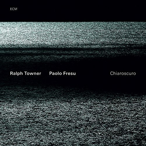 "Album cover with black and grey textured background and white text."