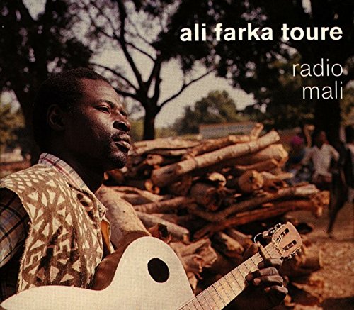 "Album cover featuring a man playing guitar outdoors with a pile of logs."