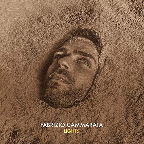 A man is buried in sand up to his head, looking upwards.