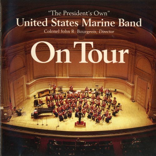 US Marine Band performing on stage in a grand concert hall.