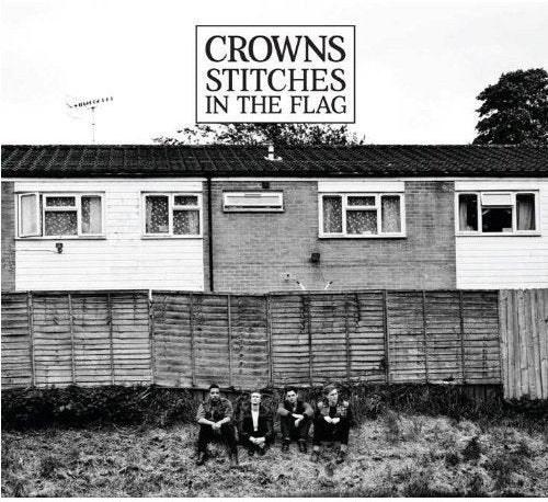 Black and white album cover featuring four men sitting in front of a house.