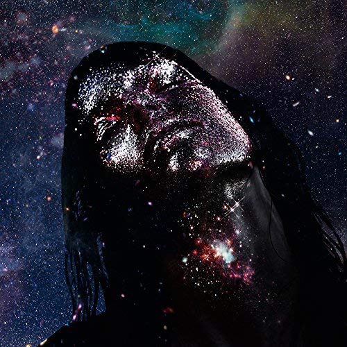 A person with dark hair and glittery skin against a starry nebula background.