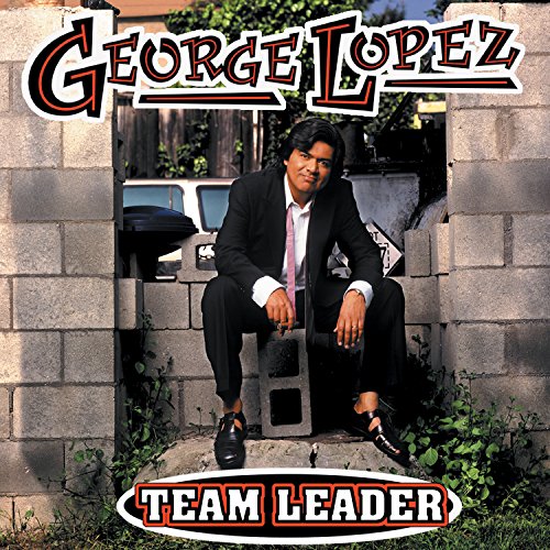 George Lopez album cover: comedian in a suit sits against a brick wall.