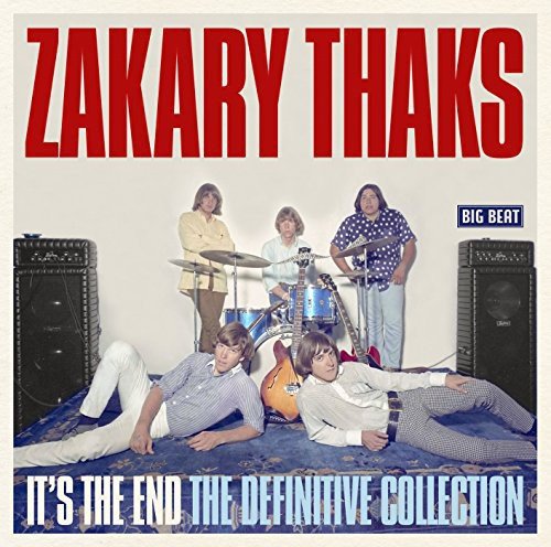 "CD cover featuring the band Zakary Thaks posing with instruments on a patterned carpet."