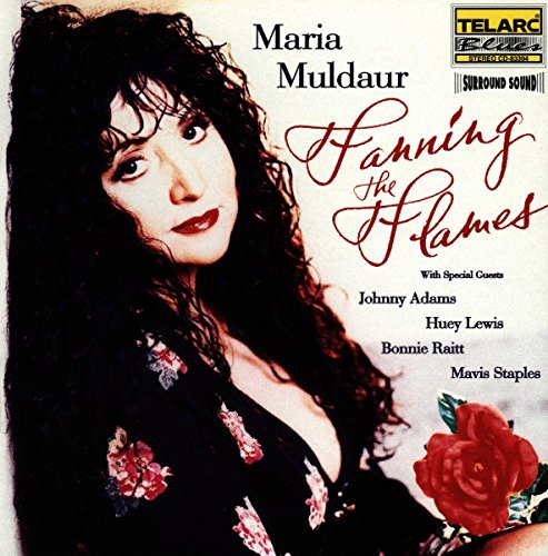 Maria Muldaur's album cover featuring a woman with long, curly hair and floral top.