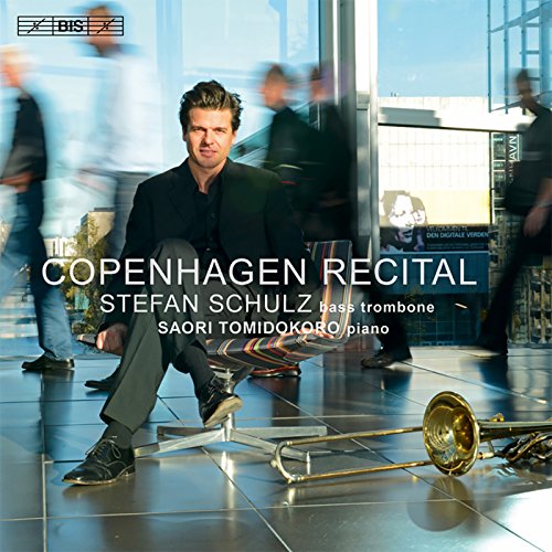 "CD cover featuring a man sitting with a trombone, blurred background."