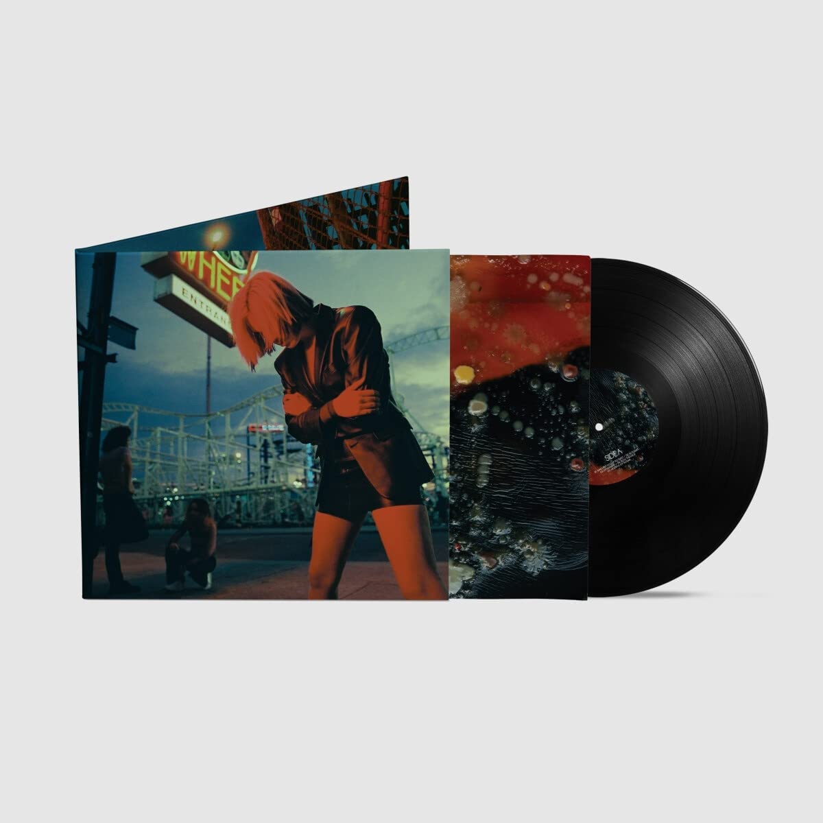 Vinyl record with cover art featuring a woman and abstract design.