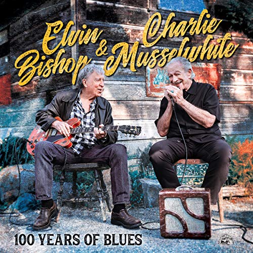 Elvin Bishop and Charlie Musselwhite seated, playing guitar and harmonica.
