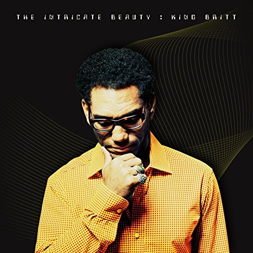 Album cover featuring a man in a yellow checkered shirt against a black background.