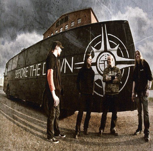 Metal band Before The Dawn poses in front of a large, dark bus.