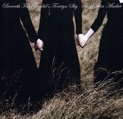 Two figures in black dresses hold hands in a grassy field.