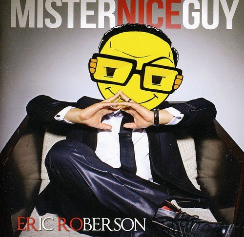 Man in suit sits with smiley face mask over his head, on album cover.