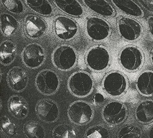 Black and white close-up of a spherical object with a grid of circular holes.