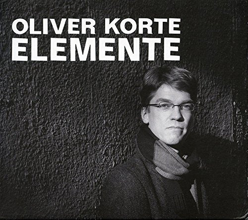Black and white album cover featuring a man in a dark coat and scarf.