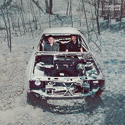 "Album cover with two men in a car without a front bumper in a wooded area."
