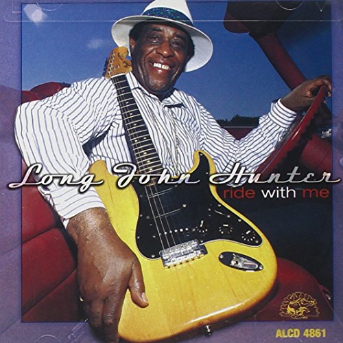 "Album cover with man in a car holding a guitar, smiling."