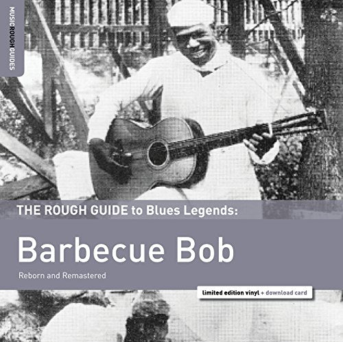 Black and white image of a man holding a guitar on a vinyl album cover.