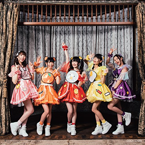 Five young women in colorful outfits pose playfully before gray curtains.