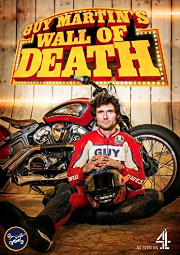 Guy Martin sits with a motorcycle in front of a "Wall of Death" sign.