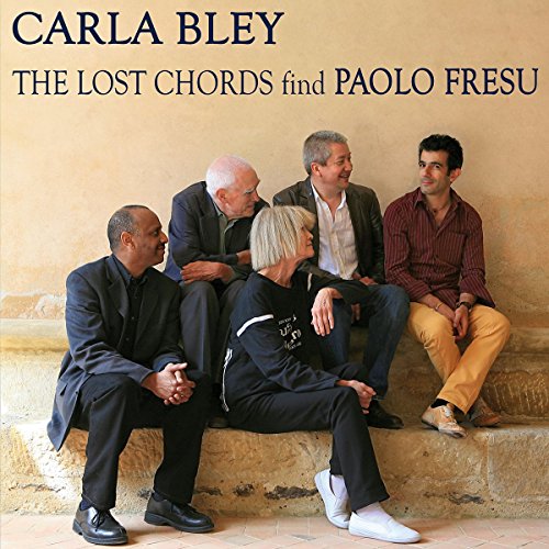 "CD cover with five musicians sitting on stone steps, against a beige wall."