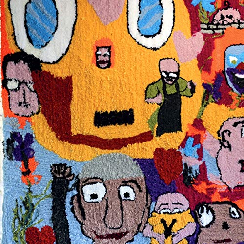 Colorful rug depicting stylized human faces and figures in a textured weave.