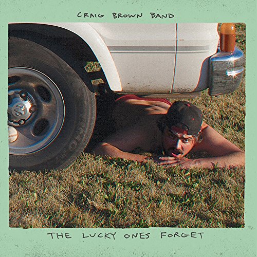 Vinyl record cover featuring a man lying under a white vehicle on grass.