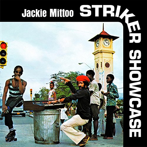 "CD cover with men playing drums on a street corner, clock tower in background."