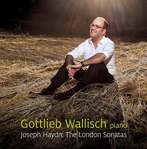 Man sitting in hay, wearing glasses, white shirt, and black pants, on album cover.