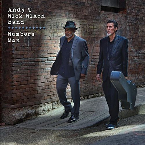 "Album cover featuring two men in suits walking beside a brick wall."