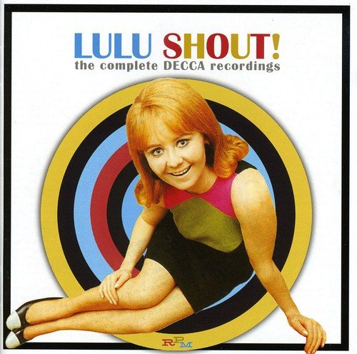 The image shows a CD cover featuring a woman sitting in front of a circular design. * The woman has red hair and is wearing a green and pink dress. * She is sitting on the ground with her legs extended to the left. * The circular design behind her consists of concentric circles in blue, red, black, and gold. * The title "LULU SHOUT!" is written in multicolored letters at the top of the image. * The subtitle "the complete DECCA