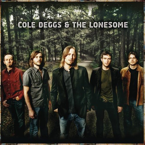 Five men stand on a dirt road in front of a forest.