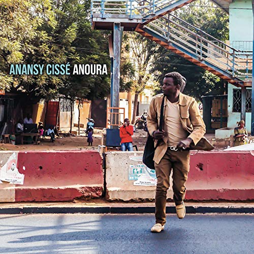 Album cover featuring a man walking on a road with a tan jacket and bag.