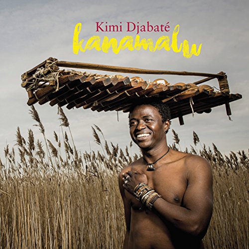 Man with a large wooden instrument on his head, in a field.