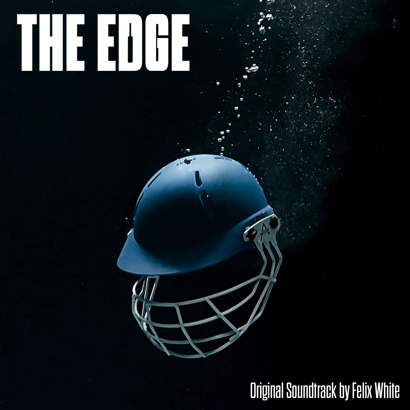 A blue cricket helmet submerged underwater with rising bubbles against a dark background.