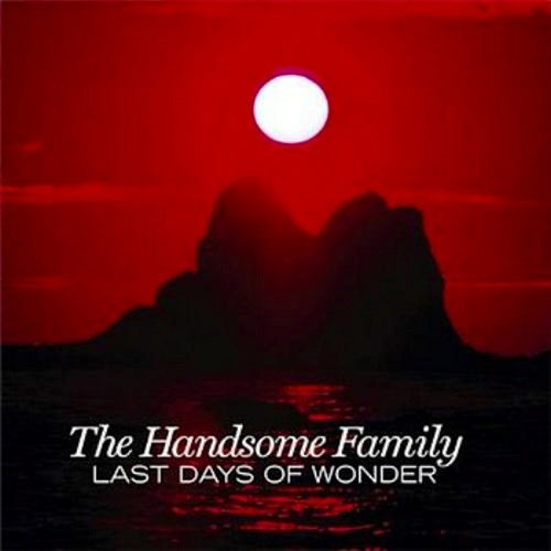 "Album cover with red sky, full moon, and silhouette of rocky island."