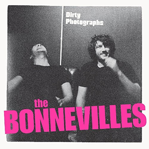 The image depicts a black-and-white album cover featuring two men. The man on the left has his head tilted back, while the man on the right has his hand to his chin. The text "Dirty Photographs" is displayed in white at the top right, and "the BONNEVILLES" is written in large pink letters across the bottom. For accessibility purposes, a concise alt text could be: "Black-and-white album cover with two men and pink text."
