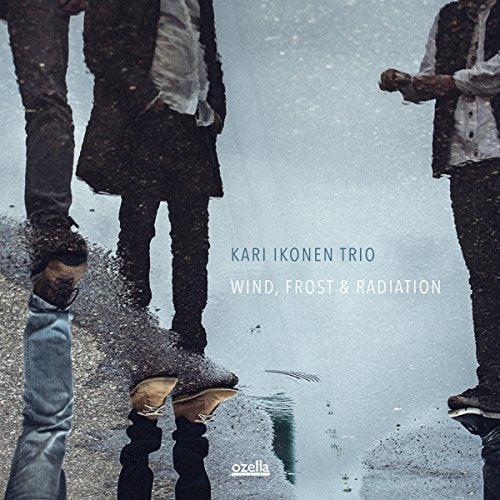"Album cover featuring three men standing in the rain, with text overlay."