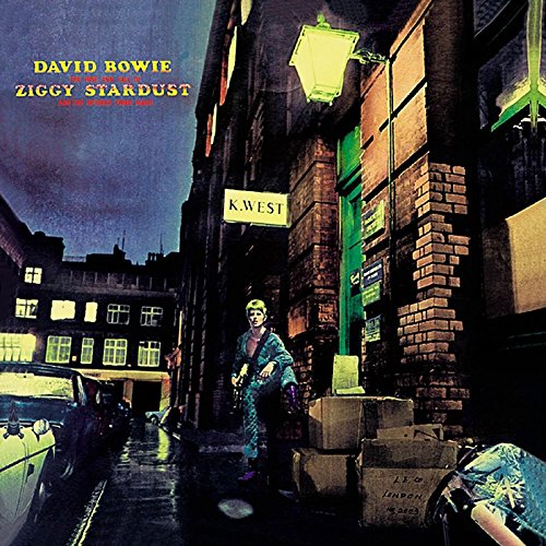 "David Bowie album cover with Ziggy Stardust standing in a dimly lit alleyway."
