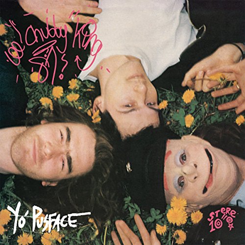 Vinyl album cover featuring three men lying in flowers with painted faces.