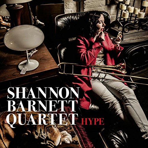 "Album cover featuring a woman sitting in a leather chair holding a trombone."