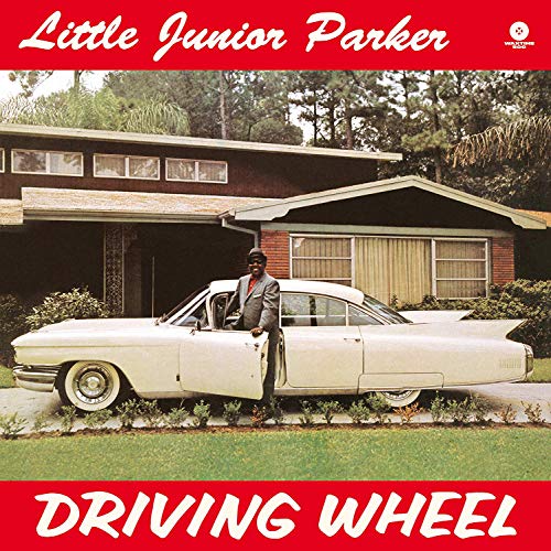 Vinyl album cover: man in suit standing beside a white car in a driveway.