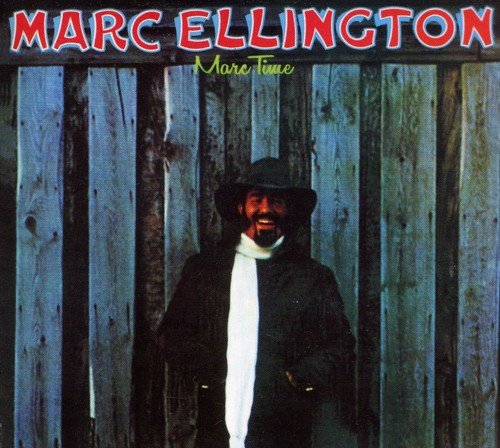 Man in a hat and dark jacket stands before a wooden fence, album cover art.