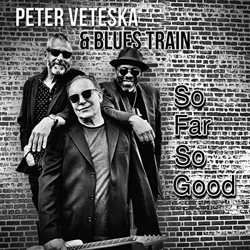 Black and white album cover featuring three men and guitar.